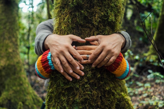 Couple homme et femme étreignant et embrassant l'arbre de tronc vert dans les bois de la forêt appréciant la nature amour et relation ensemble Concept de vie et environnement personnes style de vie Ensemble loisirs