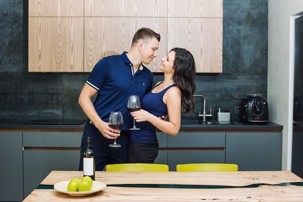 Couple homme et femme jeune belle et heureuse dans la cuisine avec des lunettes winan