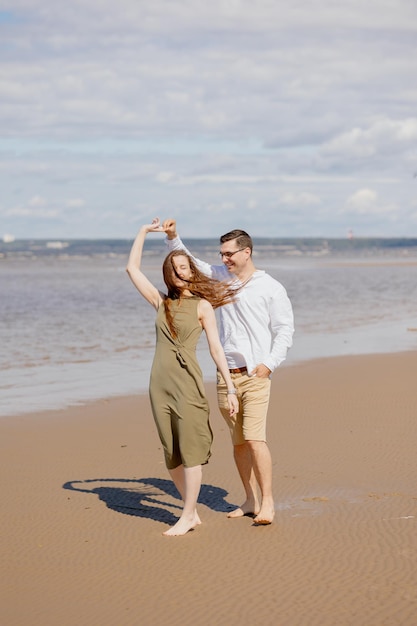 Un couple d'un homme et d'une femme marchent sur la plage ou courent le long du sable le long de la