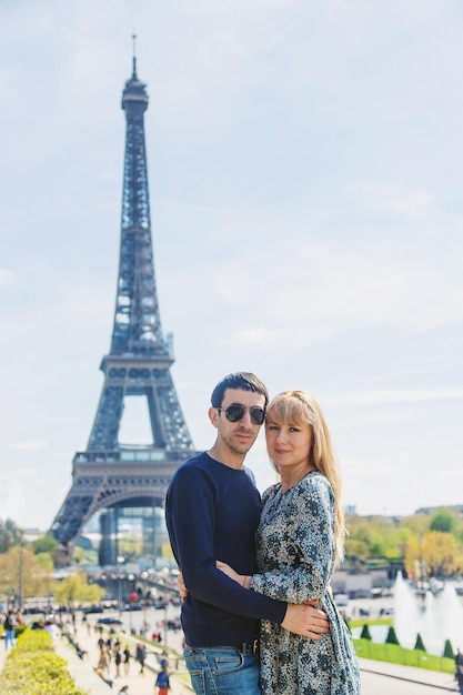 Photo couple homme et femme près de la tour eiffel mise au point sélective