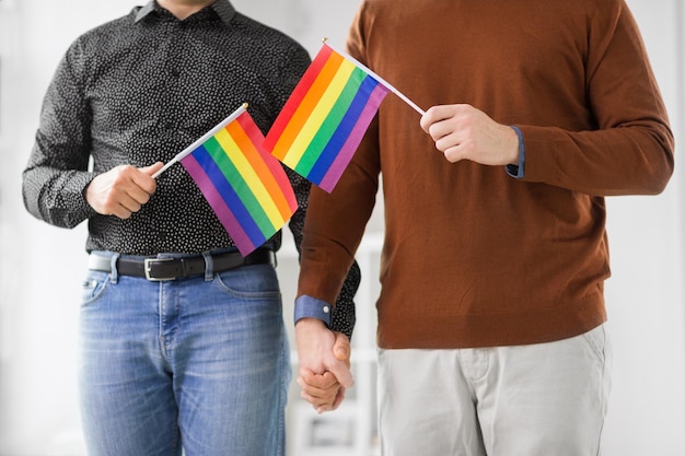 un couple d'hommes avec des drapeaux de la fierté gay se tenant par la main