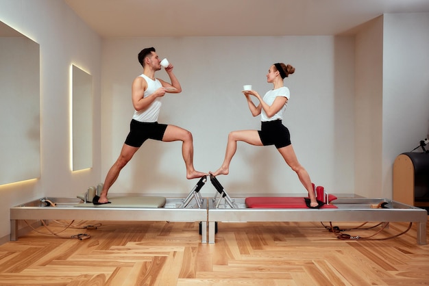 Photo un couple d'hommes et de femmes boivent du thé et du café pendant l'entraînement des palais sur le réformateur. les gens s'entraînent au gymnase.