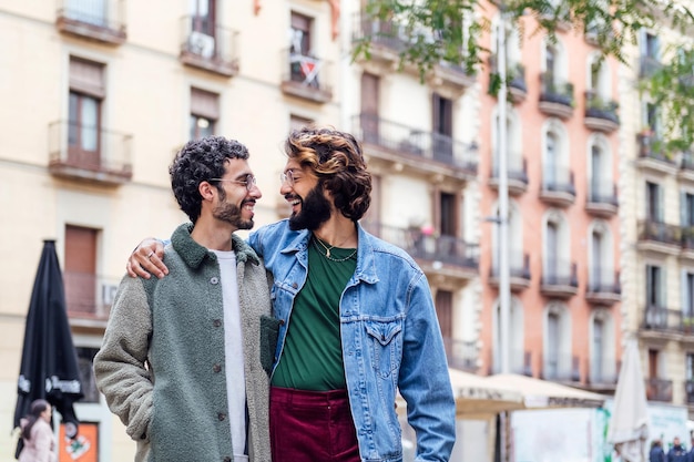 Un couple d'hommes gais marche en souriant embrassé