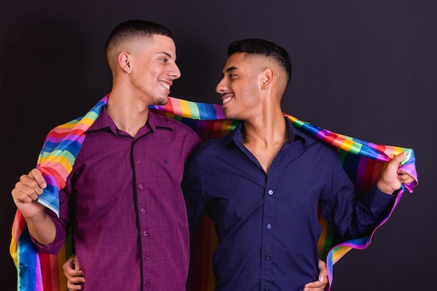 Photo couple homosexuel sur fond noir avec drapeau lgbt