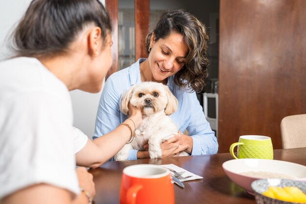 Couple homosexuel prenant son petit déjeuner dans une table en compagnie d'un petit chien