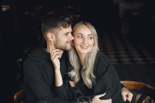 Couple hugging et boire du vin au café