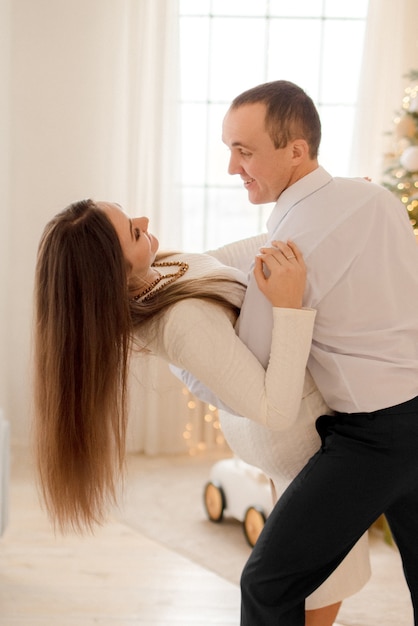 Couple hugging à la maison dans les décorations de Noël