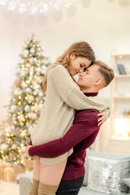 Couple hugging à la maison à la veille de Noël