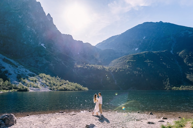 Couple hugging sur la rive d'un beau lac