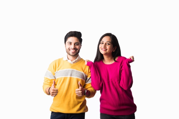 Un couple indien asiatique porte un pull chaud coloré ou des vêtements d'hiver en laine, debout isolé sur fond blanc