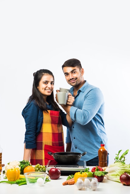 Couple indien dans la cuisine - Jeune belle femme asiatique appréciant la cuisine avec son mari avec beaucoup de fruits et légumes frais