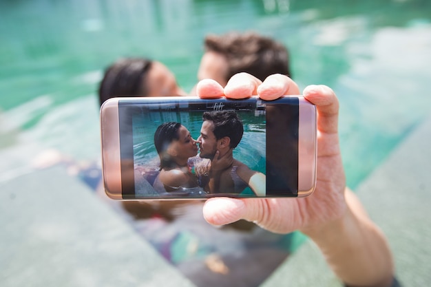 Couple interracial faisant de la photo Selfie dans la piscine