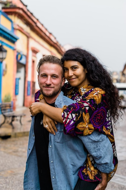 Couple interracial de jeunes amis étreignant et regardant la caméra.