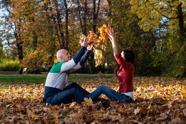 Couple jetant des feuilles en l'air