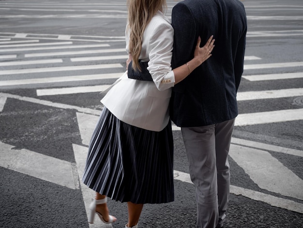 Couple un jeune homme et une femme à un passage pour piétons sur une route de la ville