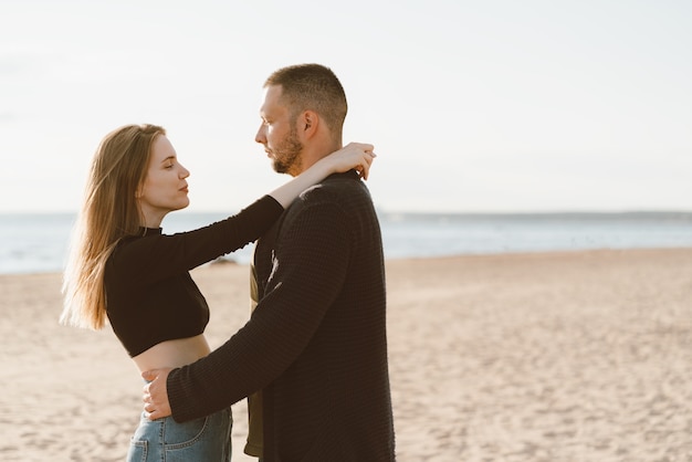 Couple de jeunes adultes debout sur la côte et se regardant. Bel homme et belle femme