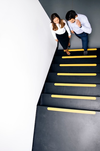 Photo couple de jeunes entrepreneurs dans l'escalier au bureau