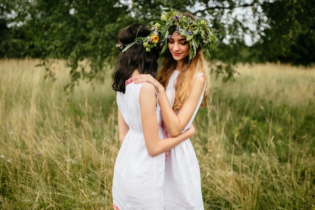 Couple de jeunes filles amoureuses. Belles femelles mignonnes d'aspect slave dans des robes païennes traditionnelles s'embrassant à la nature.