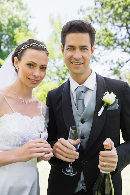 Couple de jeunes mariés ayant du champagne