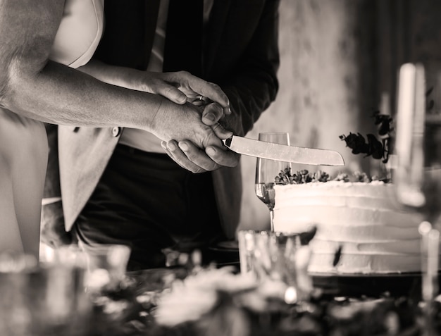 Photo couple de jeunes mariés coupant le gâteau ensemble