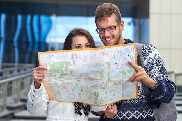 Couple de jeunes touristes lisant une carte