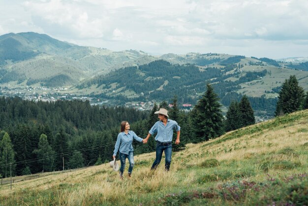 Couple de jeunes voyageurs heureux en randonnée avec des sacs à dos sur le magnifique sentier rocheux lors d'une soirée chaude et ensoleillée. Concept de voyage et d'aventure en famille.