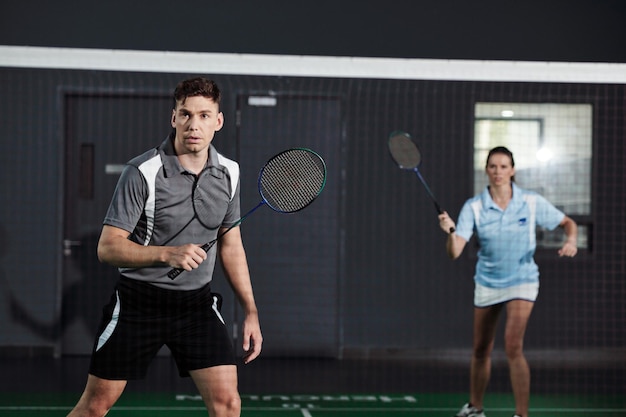 Couple jouant au badminton sur le terrain