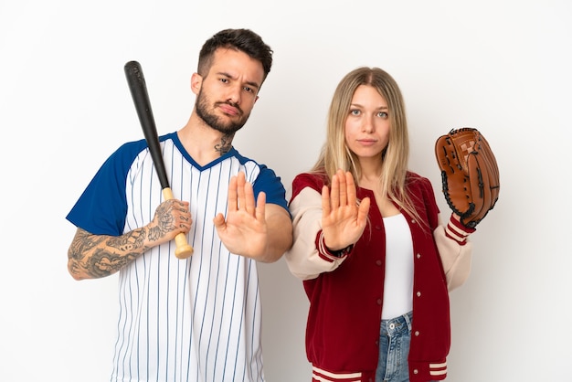 Photo couple jouant au baseball sur fond blanc isolé faisant un geste d'arrêt niant une situation qui pense mal