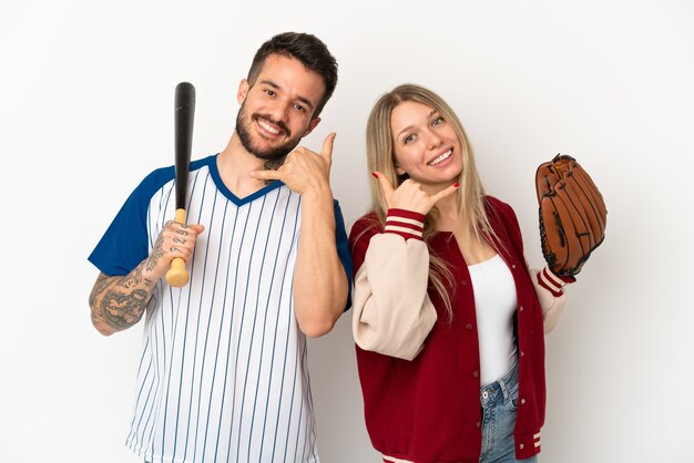 Couple jouant au baseball sur fond blanc isolé faisant un geste de téléphone. Rappelle-moi signe