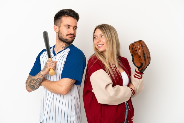 Couple jouant au baseball sur fond blanc isolé regardant par-dessus l'épaule avec un sourire