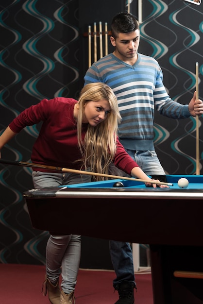 Couple jouant au billard au bar