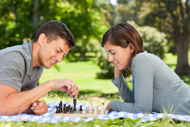 Couple jouant aux échecs dans le parc