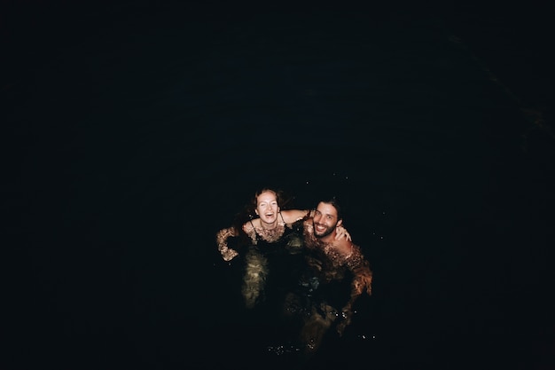 Couple jouant dans l&#39;eau sombre