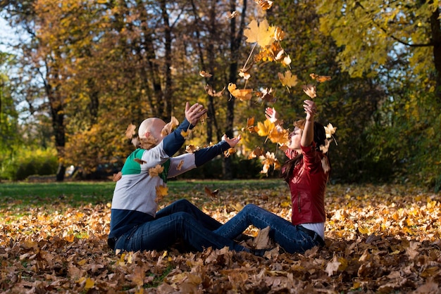 Couple jouant dans les feuilles