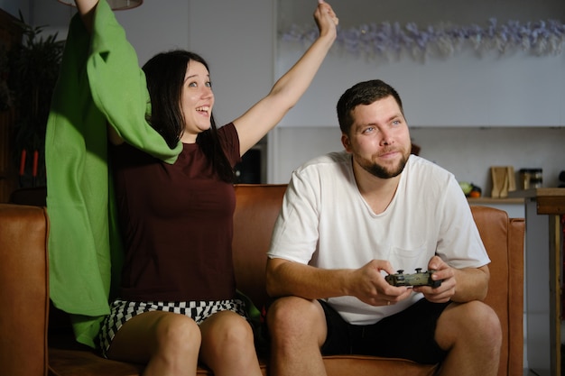 Couple jouant à des jeux vidéo sur le canapé