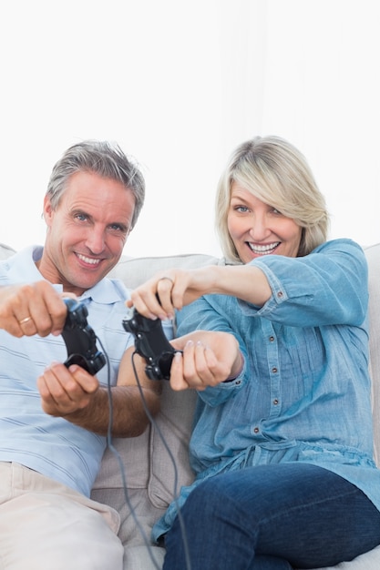 Couple jouant à des jeux vidéo ensemble sur le canapé