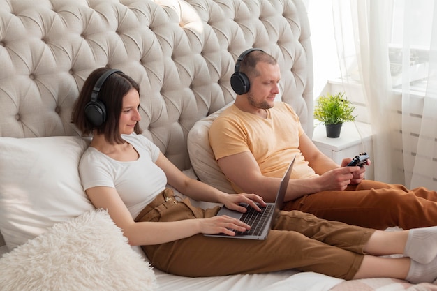 Photo couple jouant à des jeux vidéo à la maison