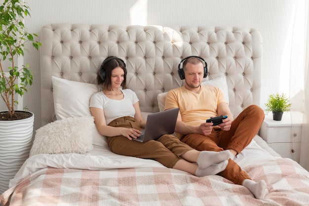 Photo couple jouant à des jeux vidéo à la maison