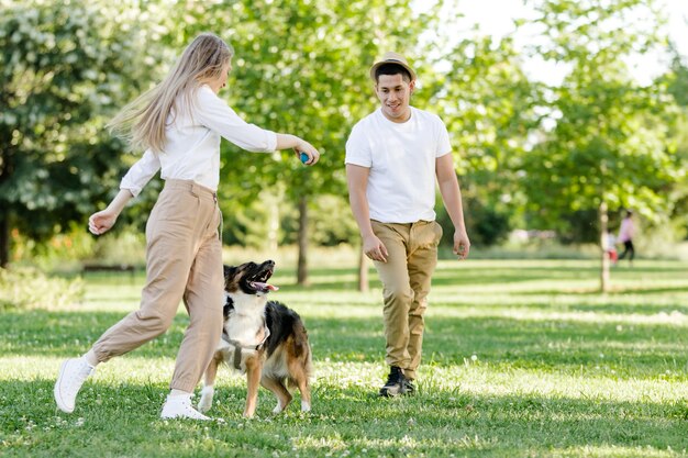 Couple jouant avec leur chien dans le parc