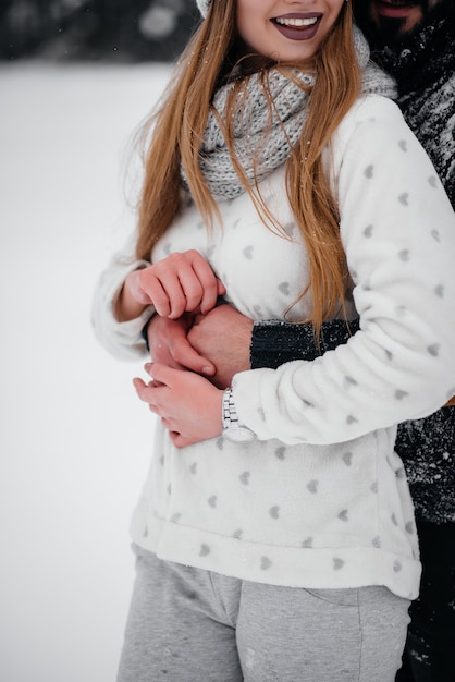 Couple jouant avec de la neige dans la forêt.