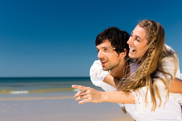 Couple jouissant de la liberté sur la plage