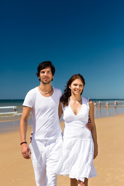 Couple jouissant de la liberté sur la plage