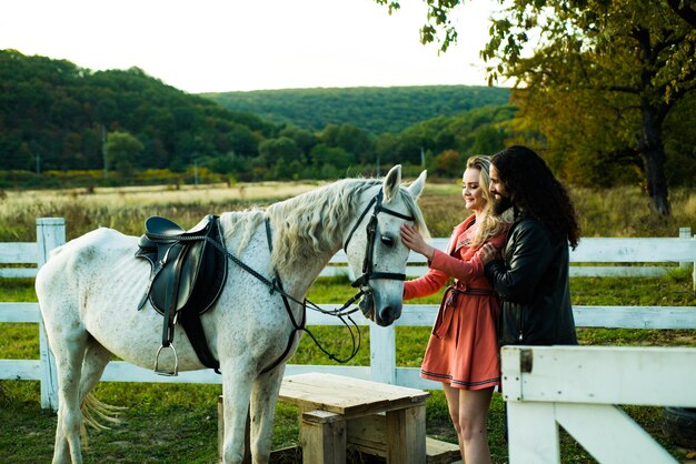 Couple joyeux romantique avec cheval flirter et jouer. Les jeunes amoureux de l'équitation.