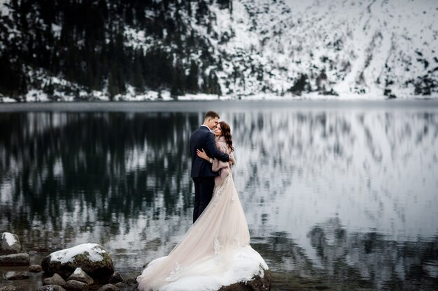 Couple juste marié s'embrassant sur le paysage des montagnes