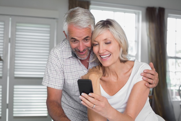 Couple, lecture de SMS à la maison