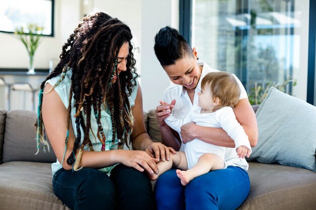 Couple de lesbiennes jouant avec leur bébé dans le salon