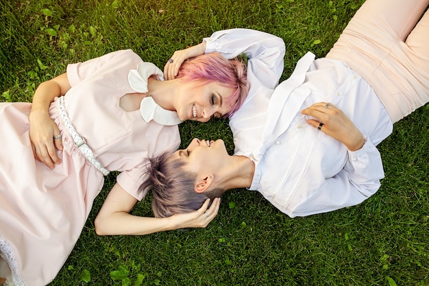 Couple de lesbiennes multiraciales allongé sur l&#39;herbe.