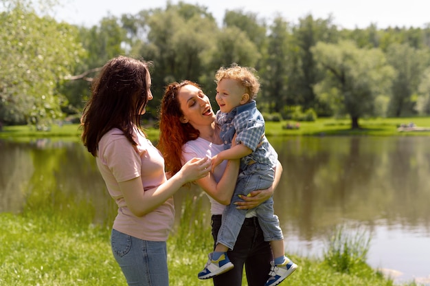 Photo couple de lesbiennes passant du temps avec leur fils dans le parc