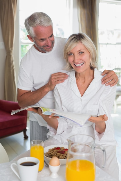 Couple lisant un journal en prenant son petit déjeuner