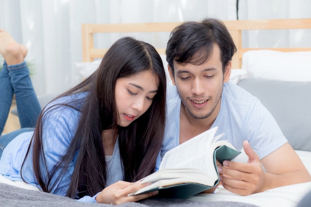 Couple lisant un livre ensemble dans la chambre le matin avec bonheur.